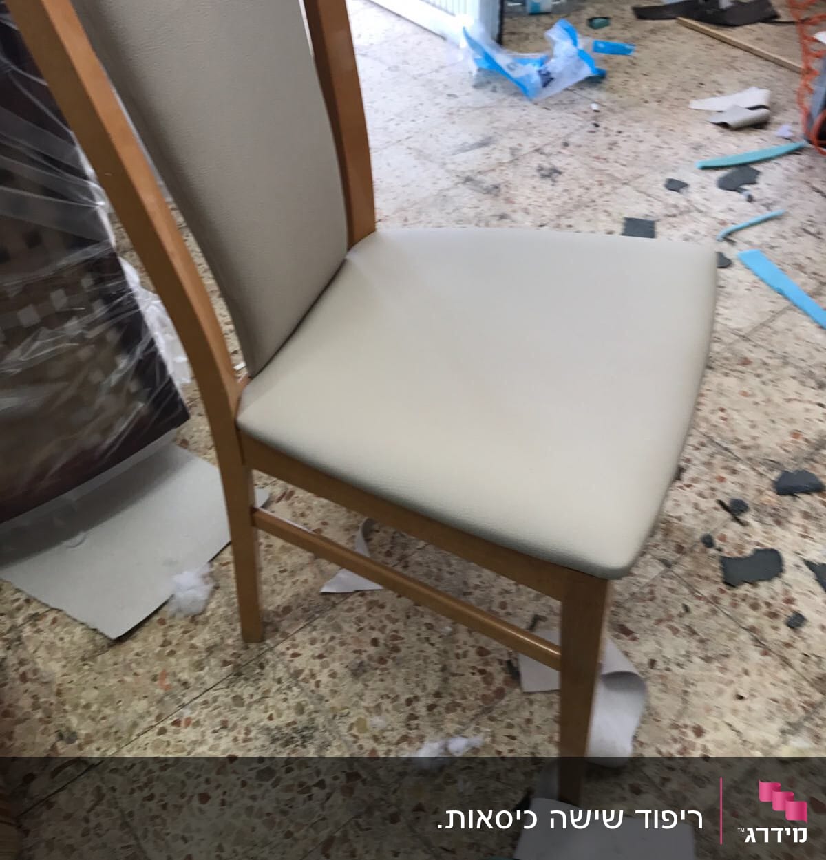 כיסא מרופד עם ריפוד בהיר על רצפה עם שאריות בד